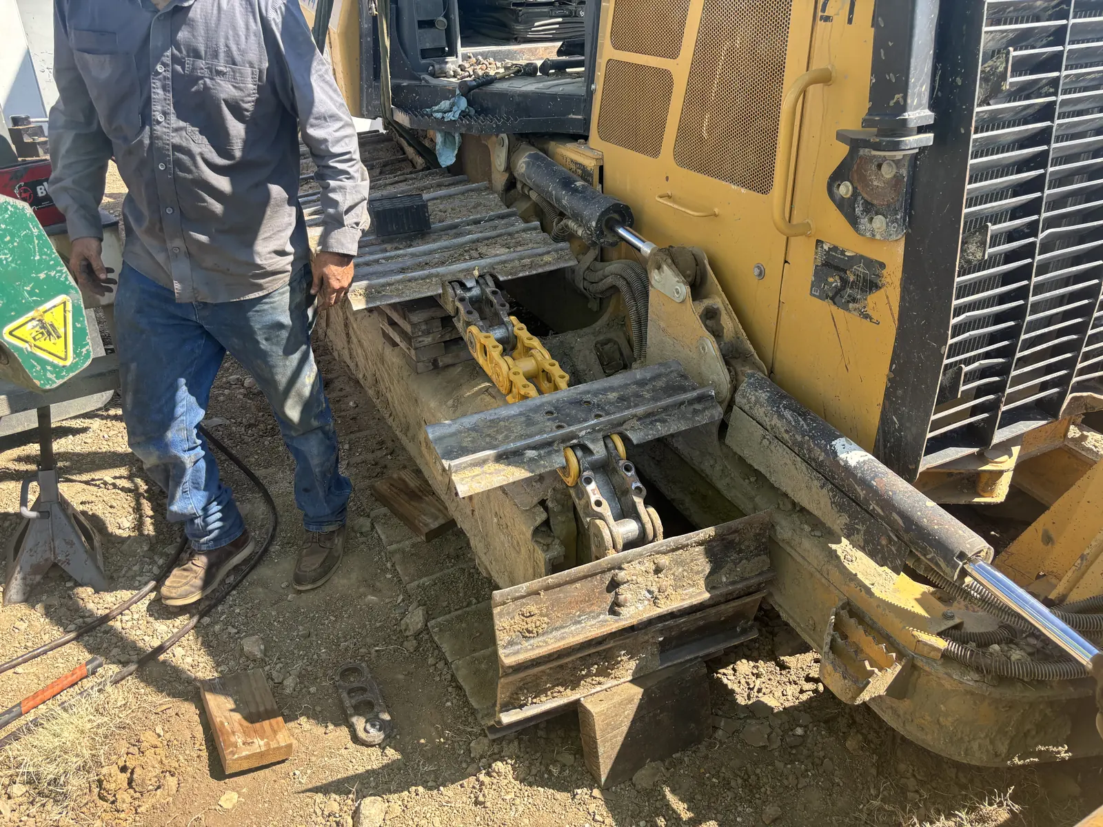 Technician repairing a dozer track in the field