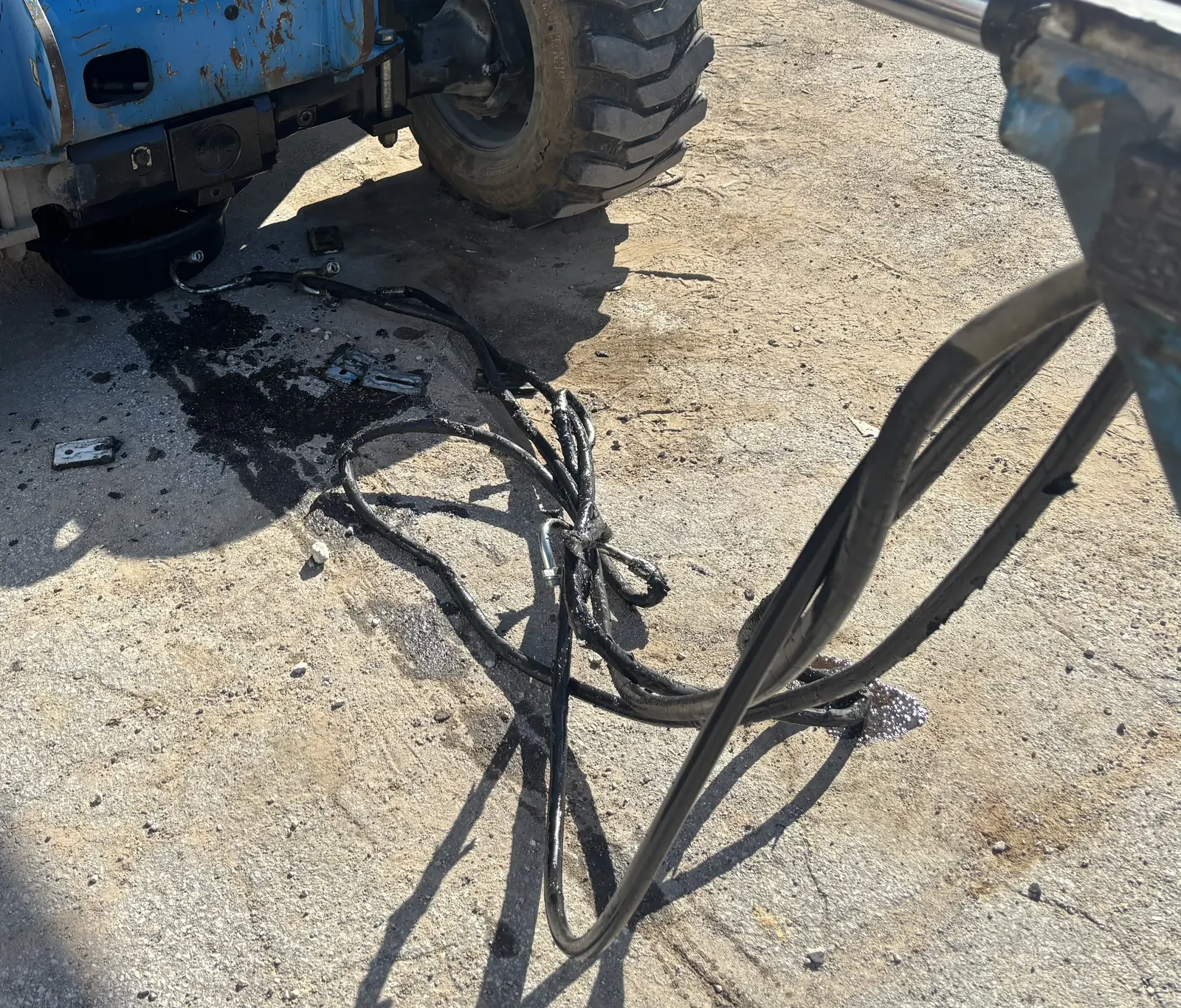 Technician repairing a damaged wiring harness on heavy equipment