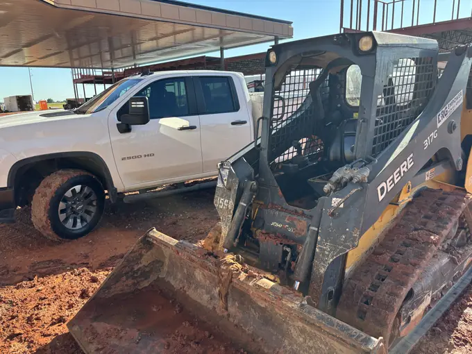 John Deere skid steer and service truck at a jobsite repair