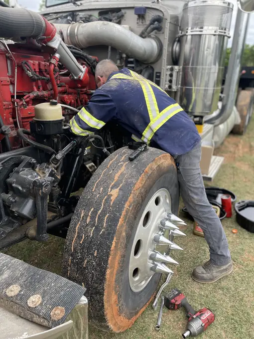 Mobile mechanic performing diesel engine repair in the field