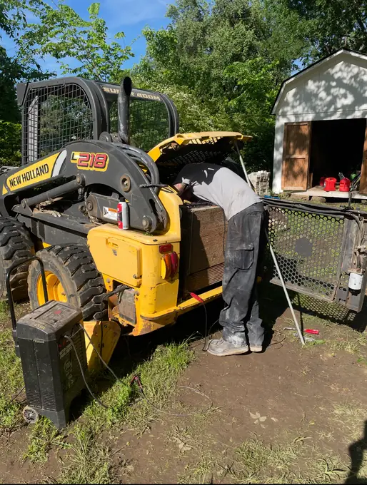 Tulsa Fleet Repair technician servicing a skid steer on-site