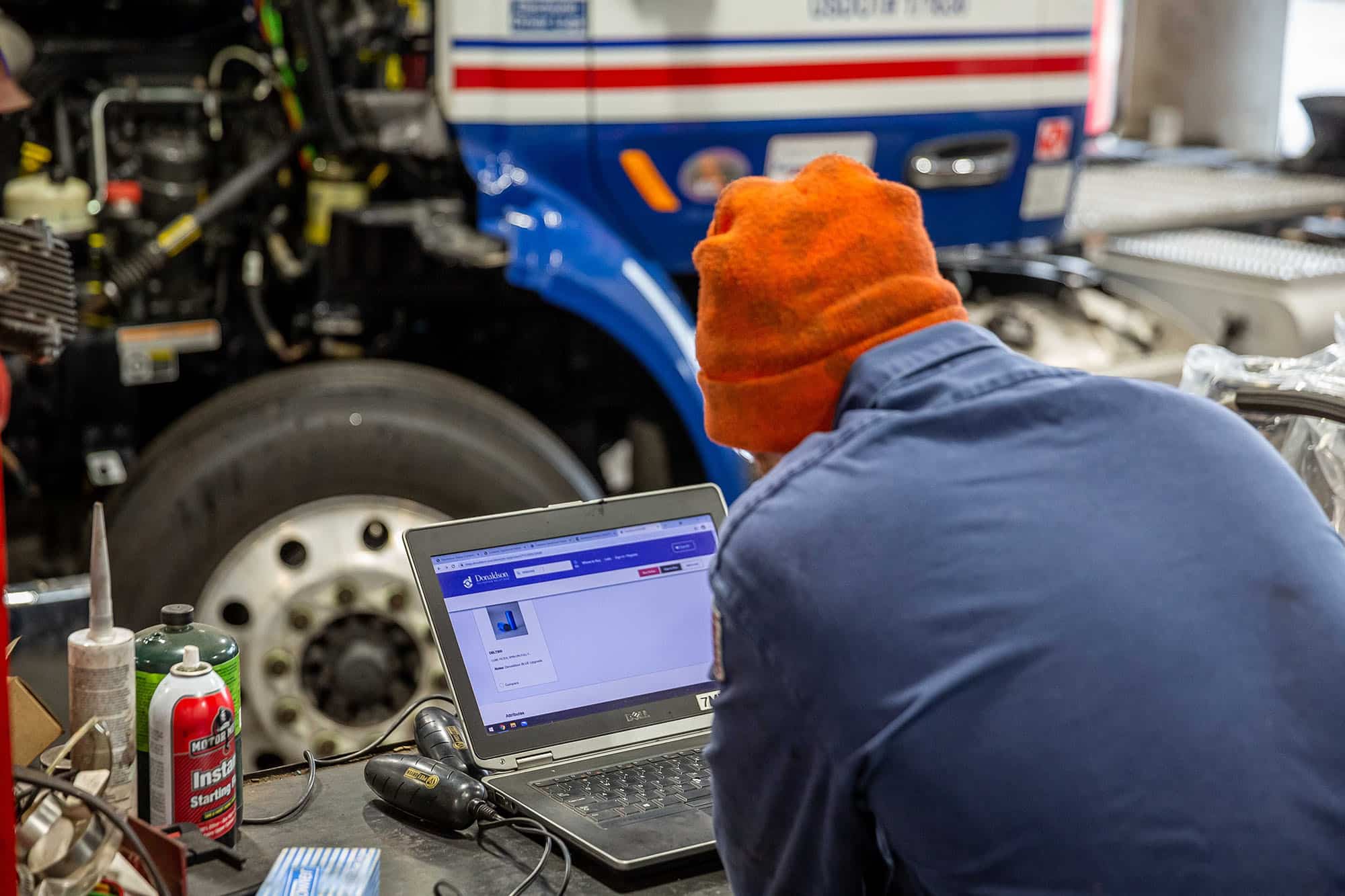 Technician performing diagnostic check on a commercial truck